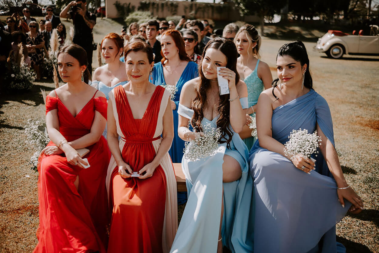 Mulheres sentada assistindo emocionadas ao casamento