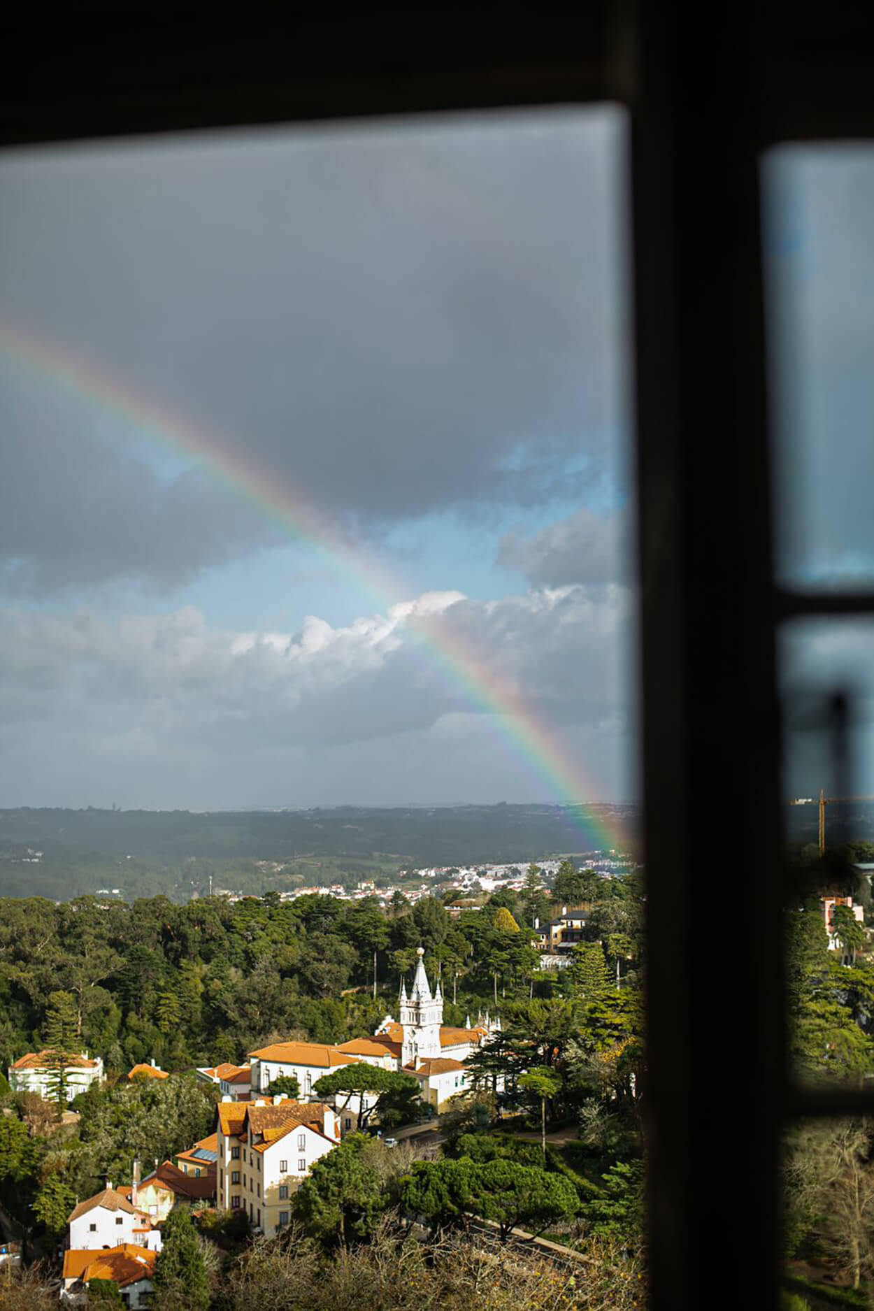 Visão da janela de igreja branca com arco íris no céu
