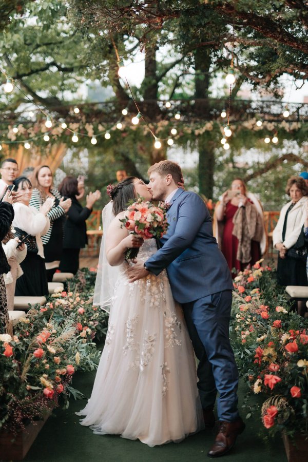 capa post: Noivos se beijando e convidados aplaudindo