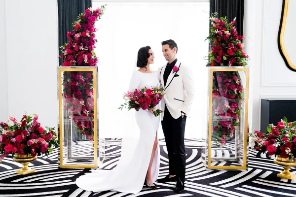 capa post: Casal em frente ao altar de casamento clássico moderno com decoração em tons de magenta