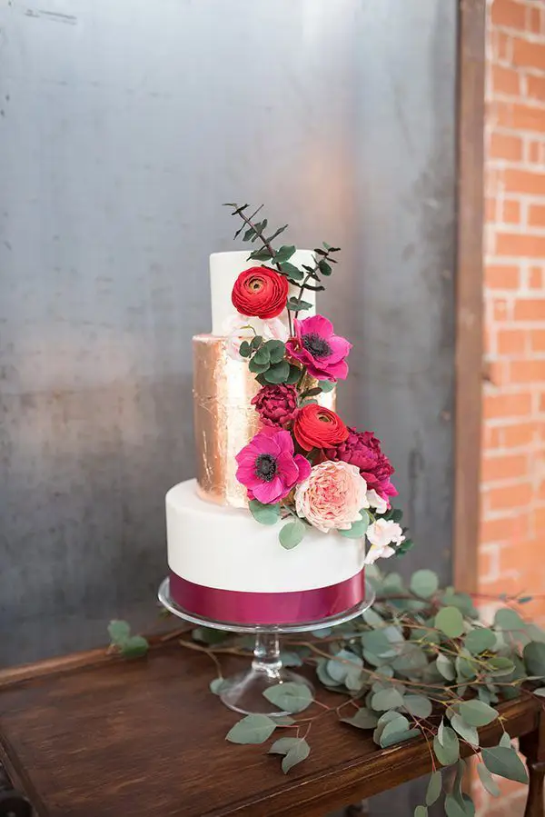 bolo de casamento de três andarem branco e dourado com aplicação de fita cor magenta e flores em tons de rosa
