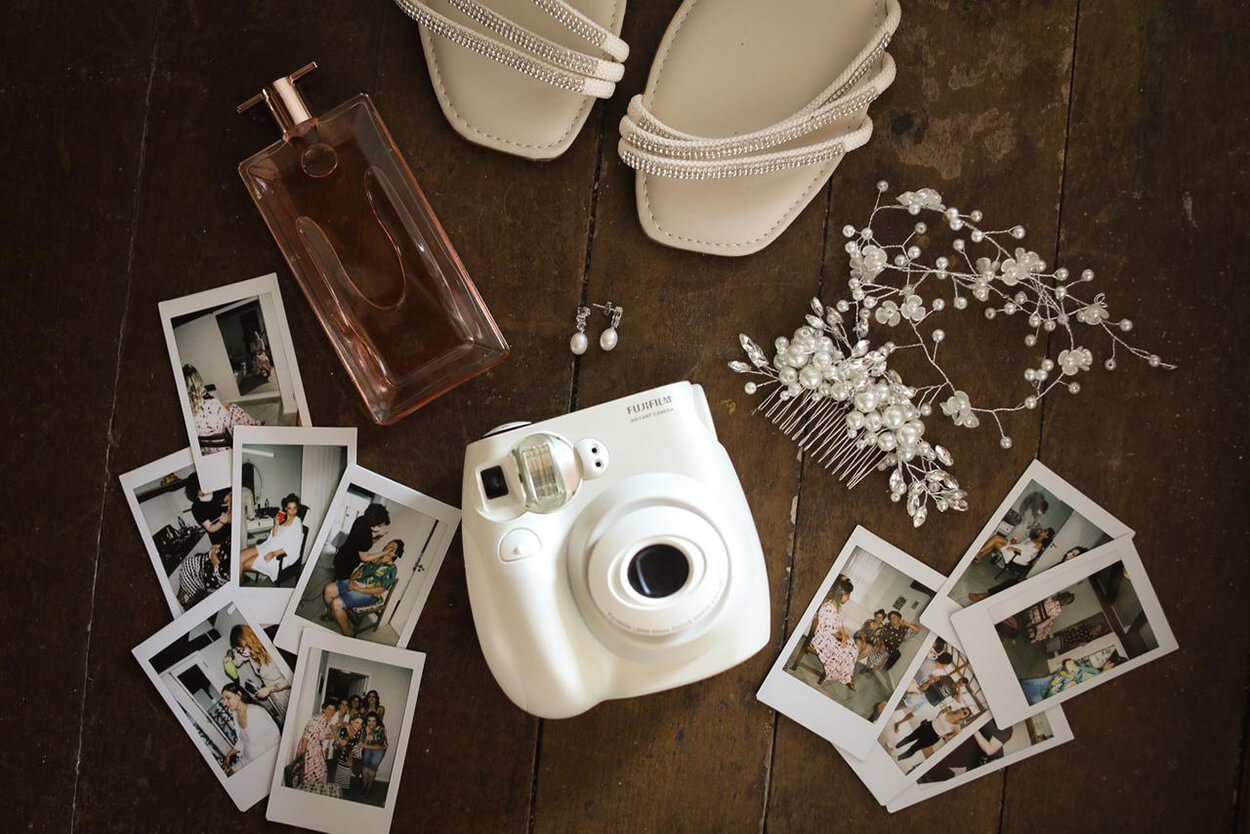 Câmera instantânea branca com fotos polaroids sobre a mesa
