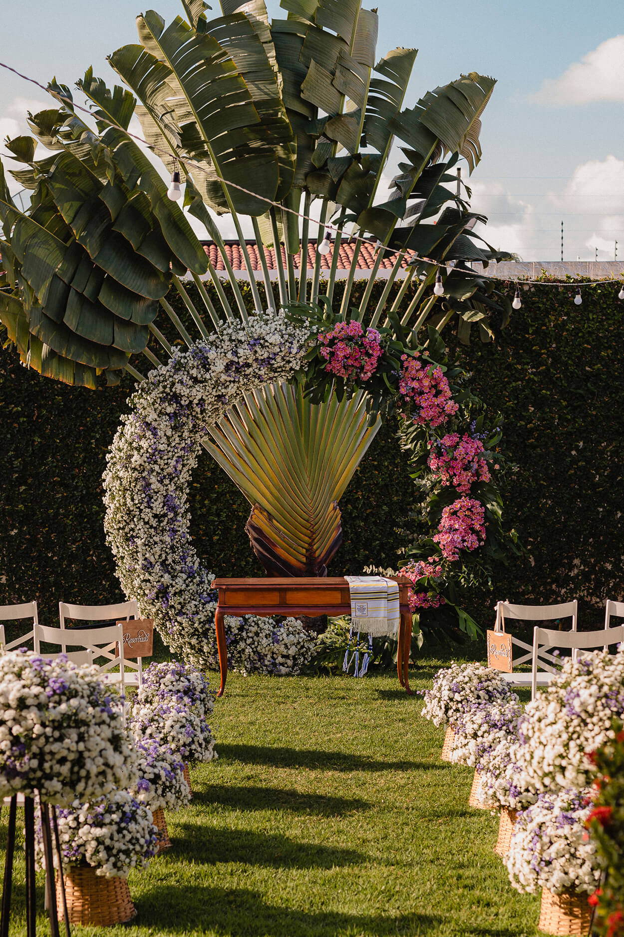 Altar circular com metade composta por flores brancas e lilás e a outra metade por flores rosas