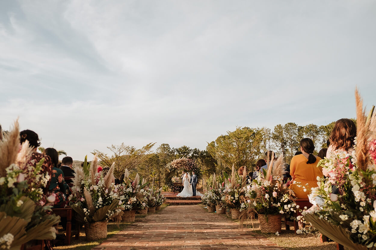 Vista ao longe dos noivos no altar durante casamento ao ar livre
