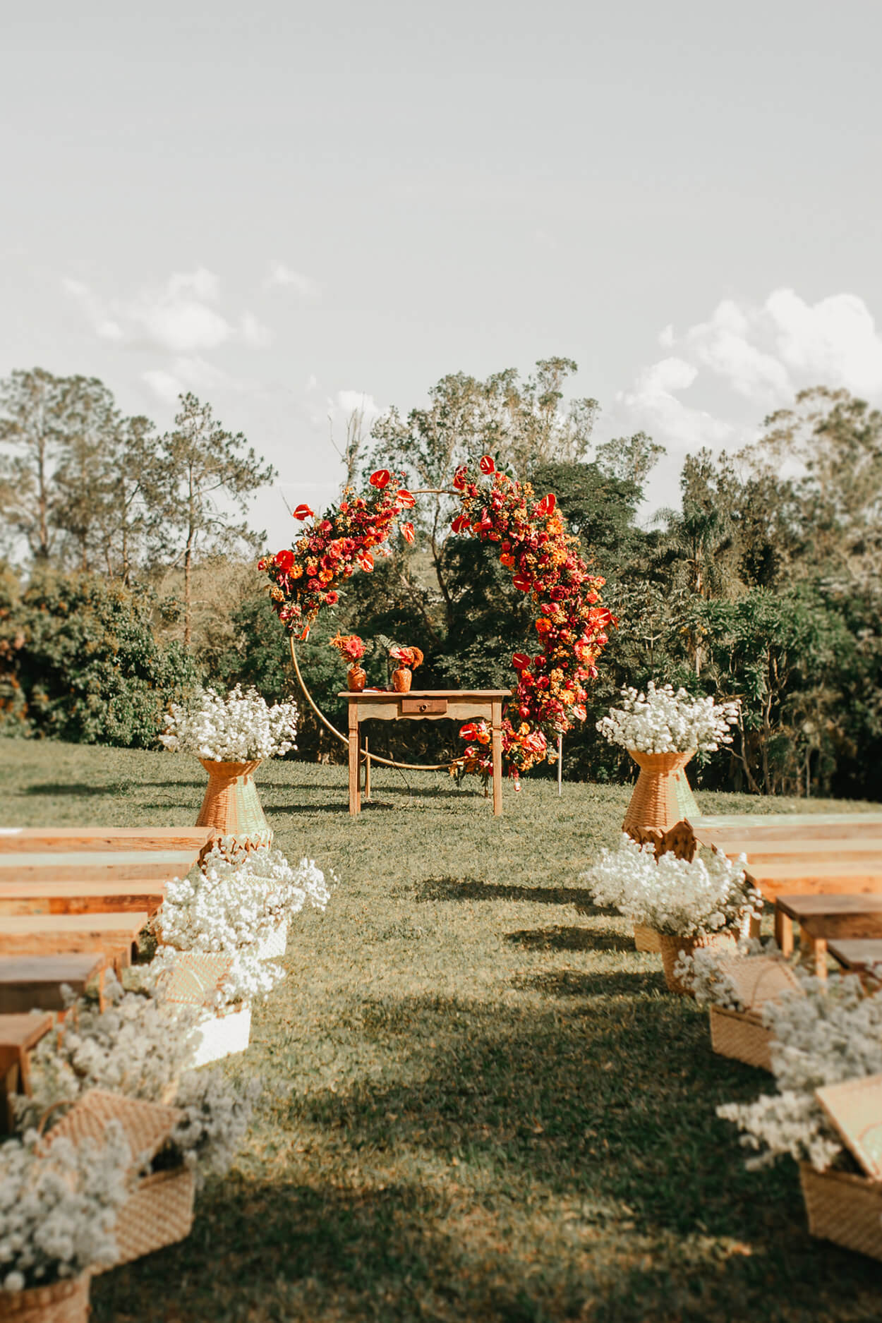 Altar circular com flores laranjas e vermelhas no campo