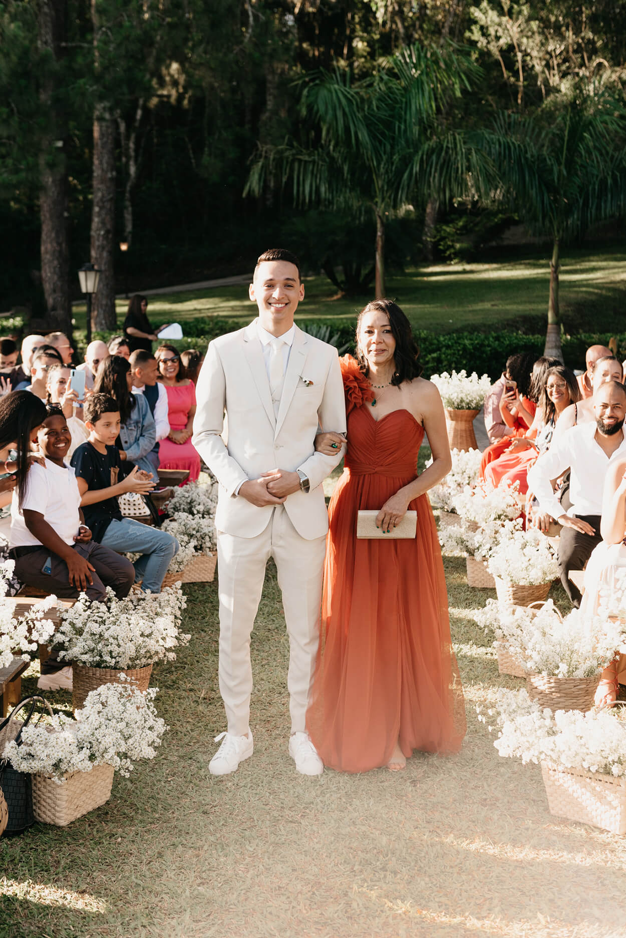 Entrada do noivo com terno off white com sua mãe de vestido terracota