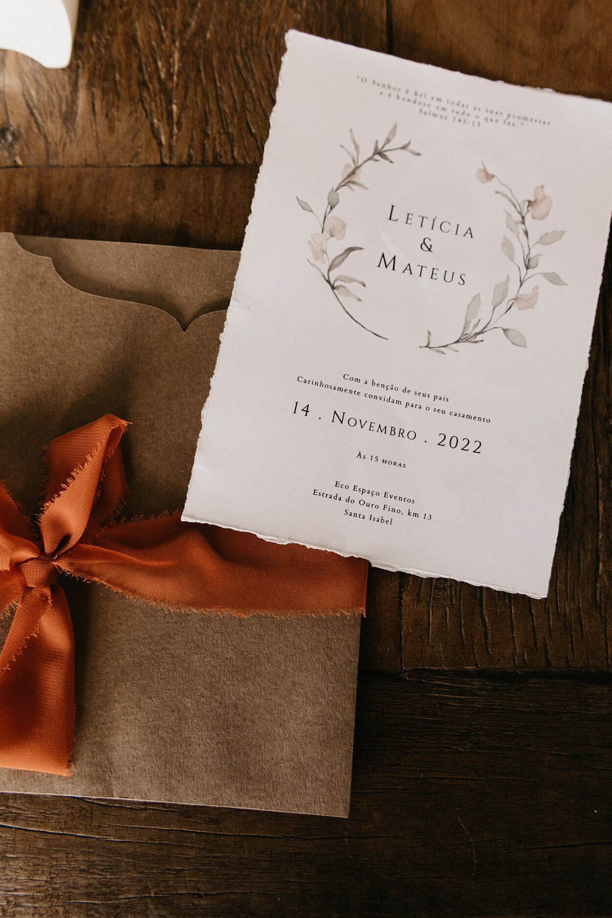 Convite de casamento branco e envelope em papel pardo com laço laranja