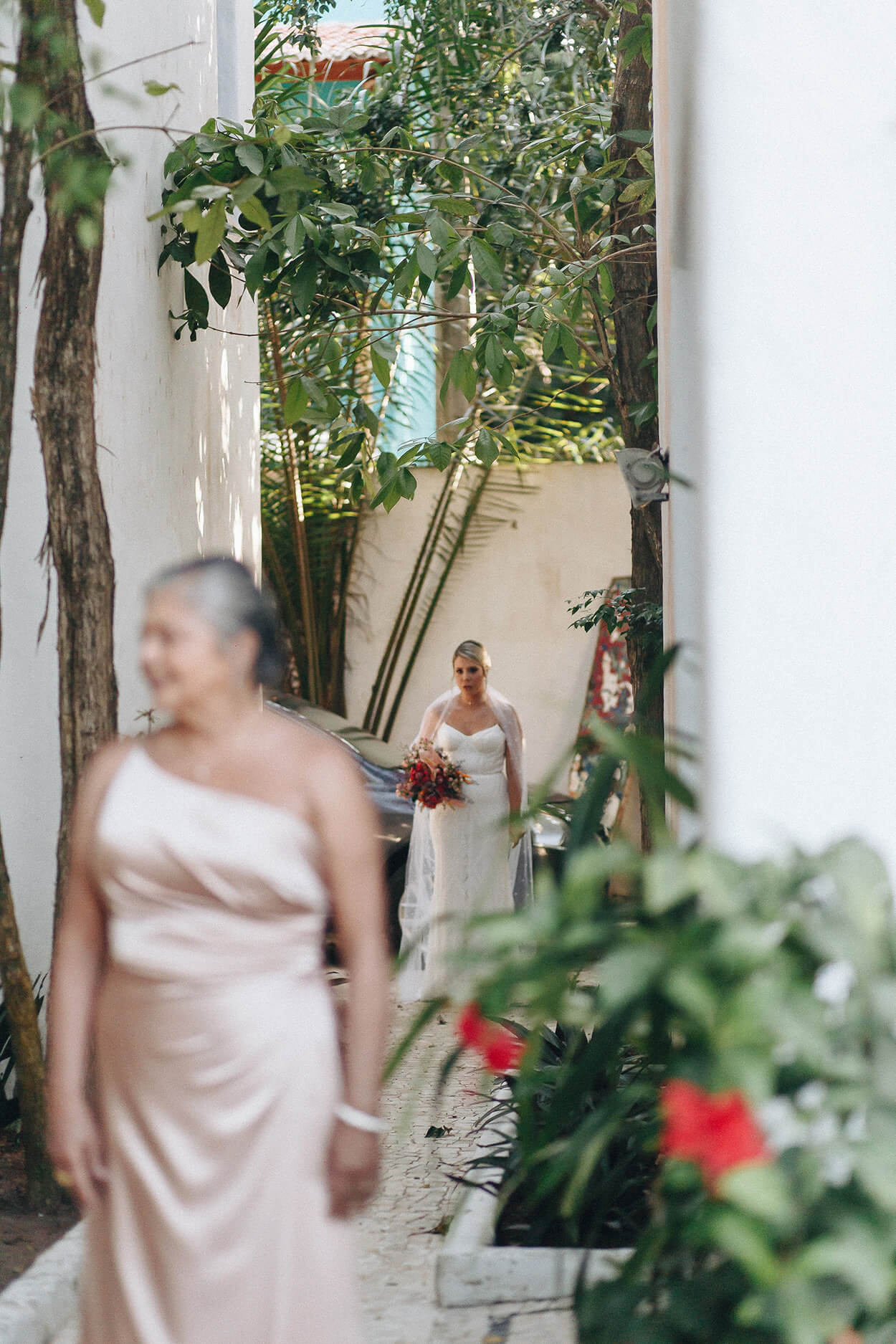 Noiva caminhando em direção a mãe de costas usando vestido rosê brilhante