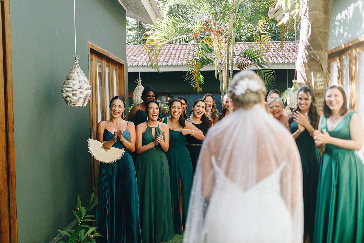 Madrinhas com vestidos verde animadas vendo a noiva pela primeira vez