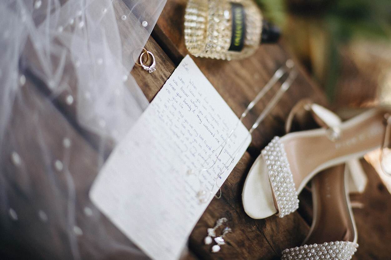 Carta escrita à mão e sapato com aplique de pérolas sobre mesa de madeira