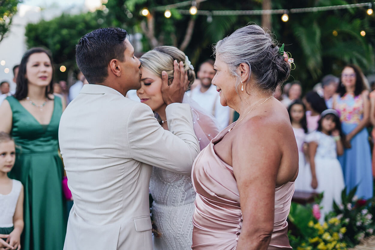 Noivo beijando a testa da noiva durante a cerimônia de casamento