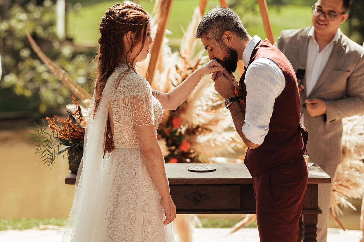 Noivo beijando a mão da noiva no altar