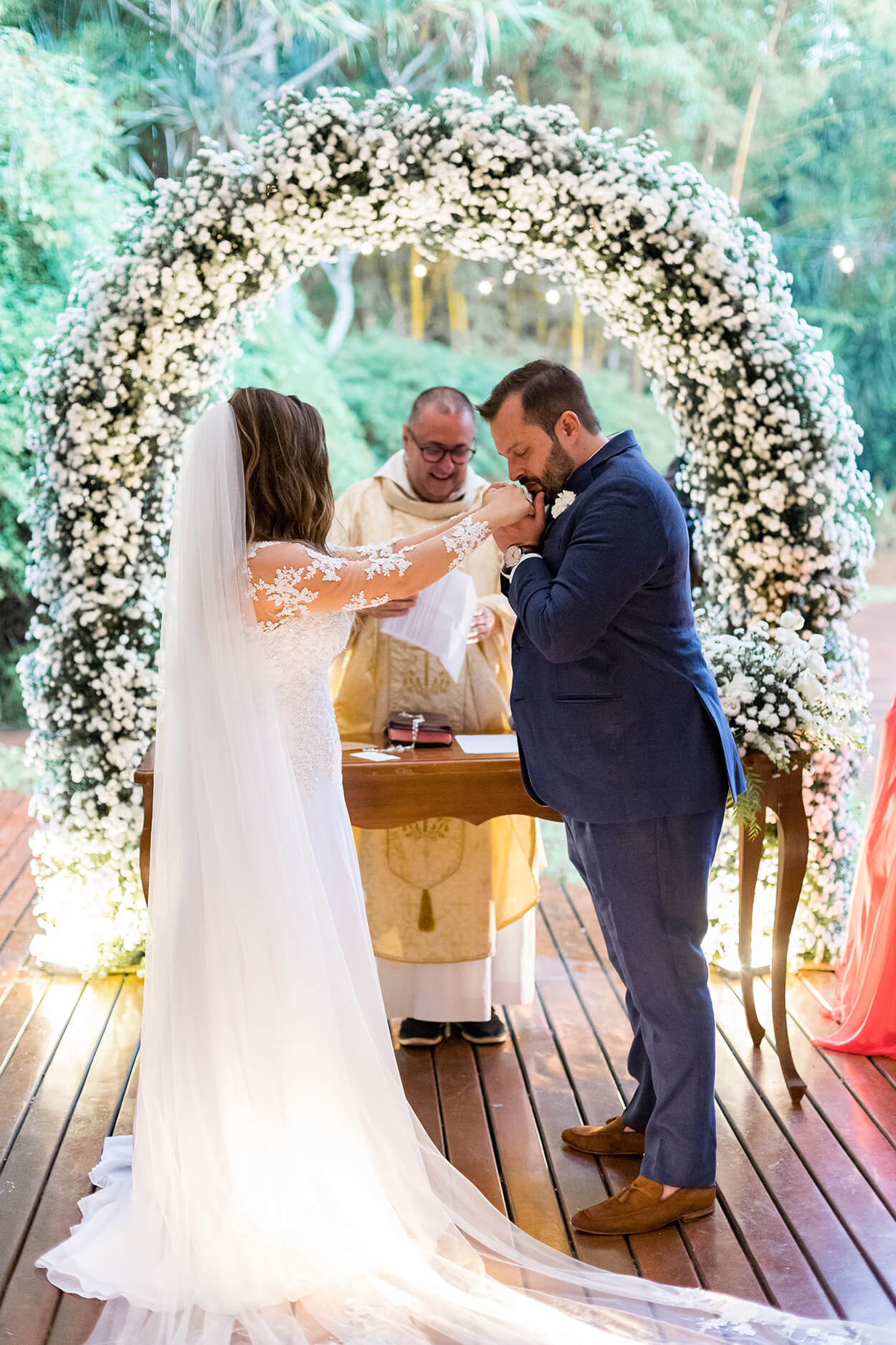 Noivo beijando a mão da noiva na frente do altar