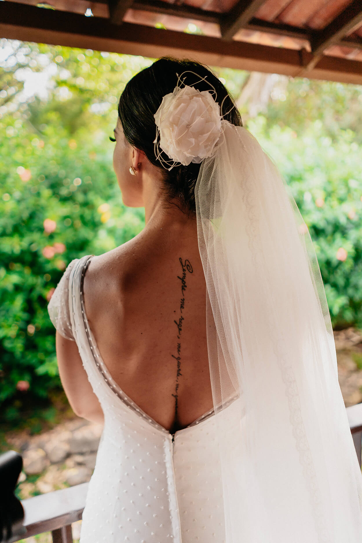 Mulher de costas com vestido de noiva com decote e grinalda floral