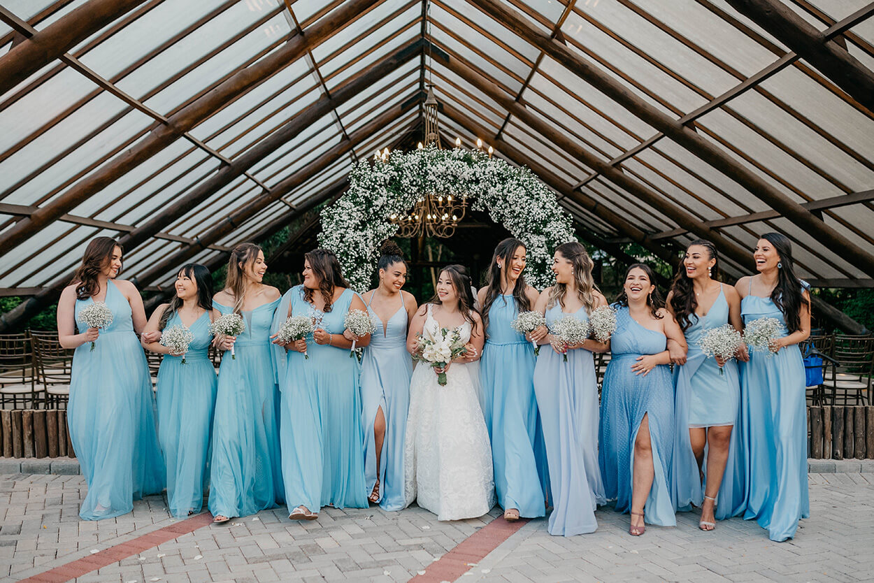 Noiva e madrinhas com vestido azul claro ao lado