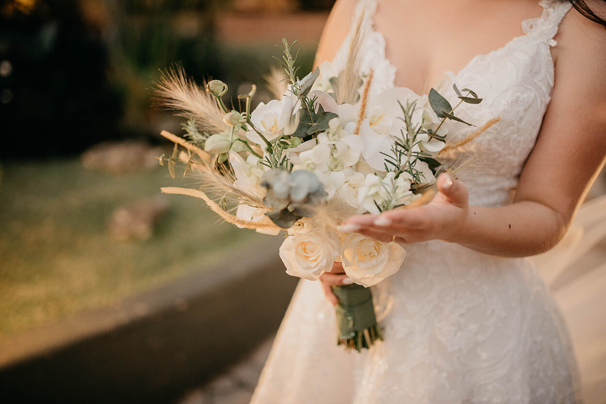 Noiva segurando buquê com rosas brancas, capim dos pampas e ramos de eucalipto