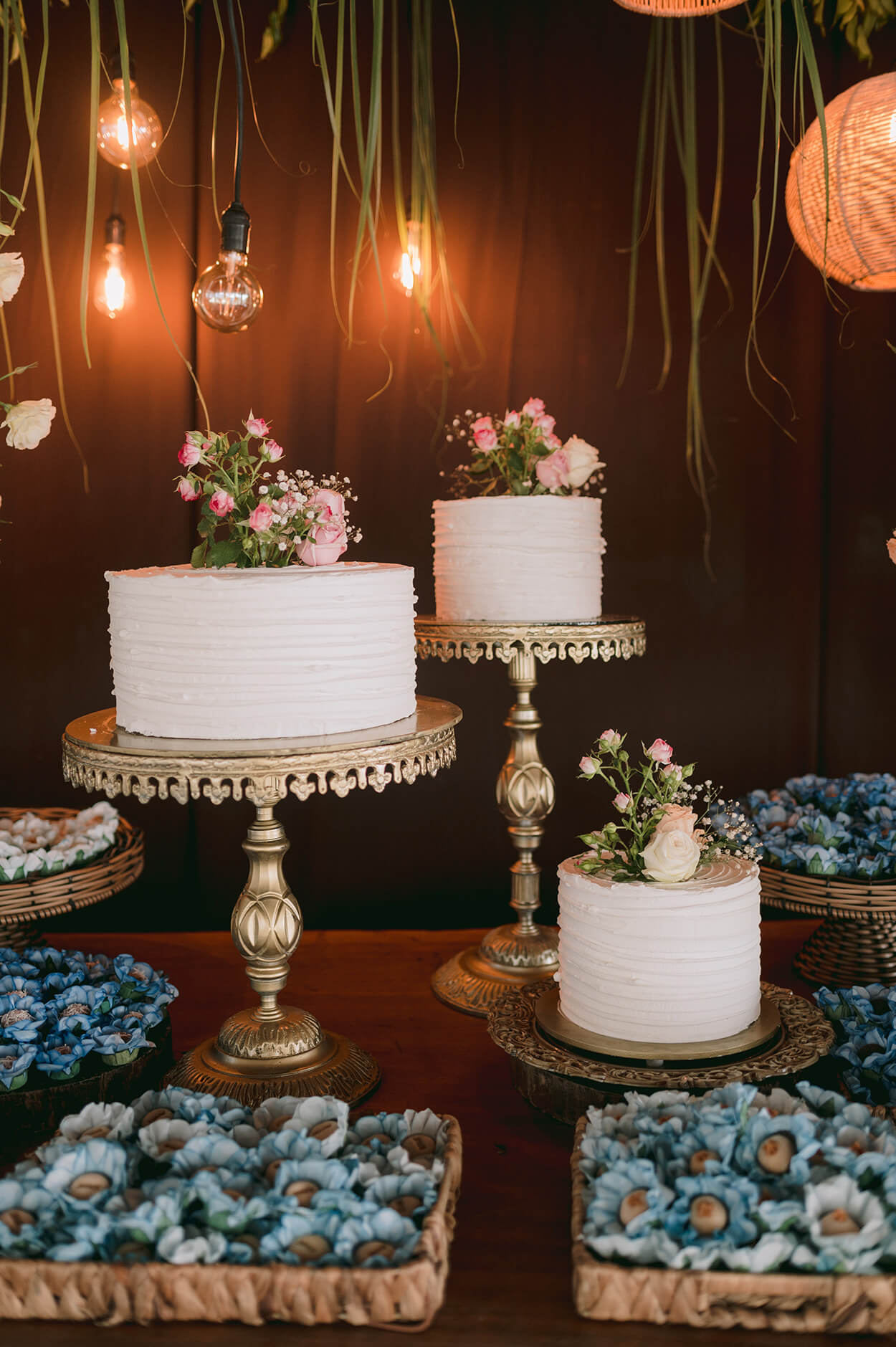 Trio de bolos brancos de casamento com flores rosas no topo