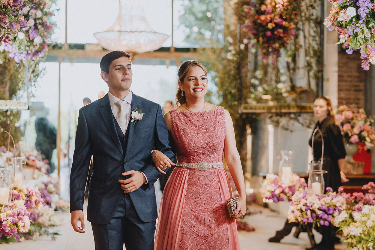 Entrada do noivo com a mão usando vestido rosa brilhante