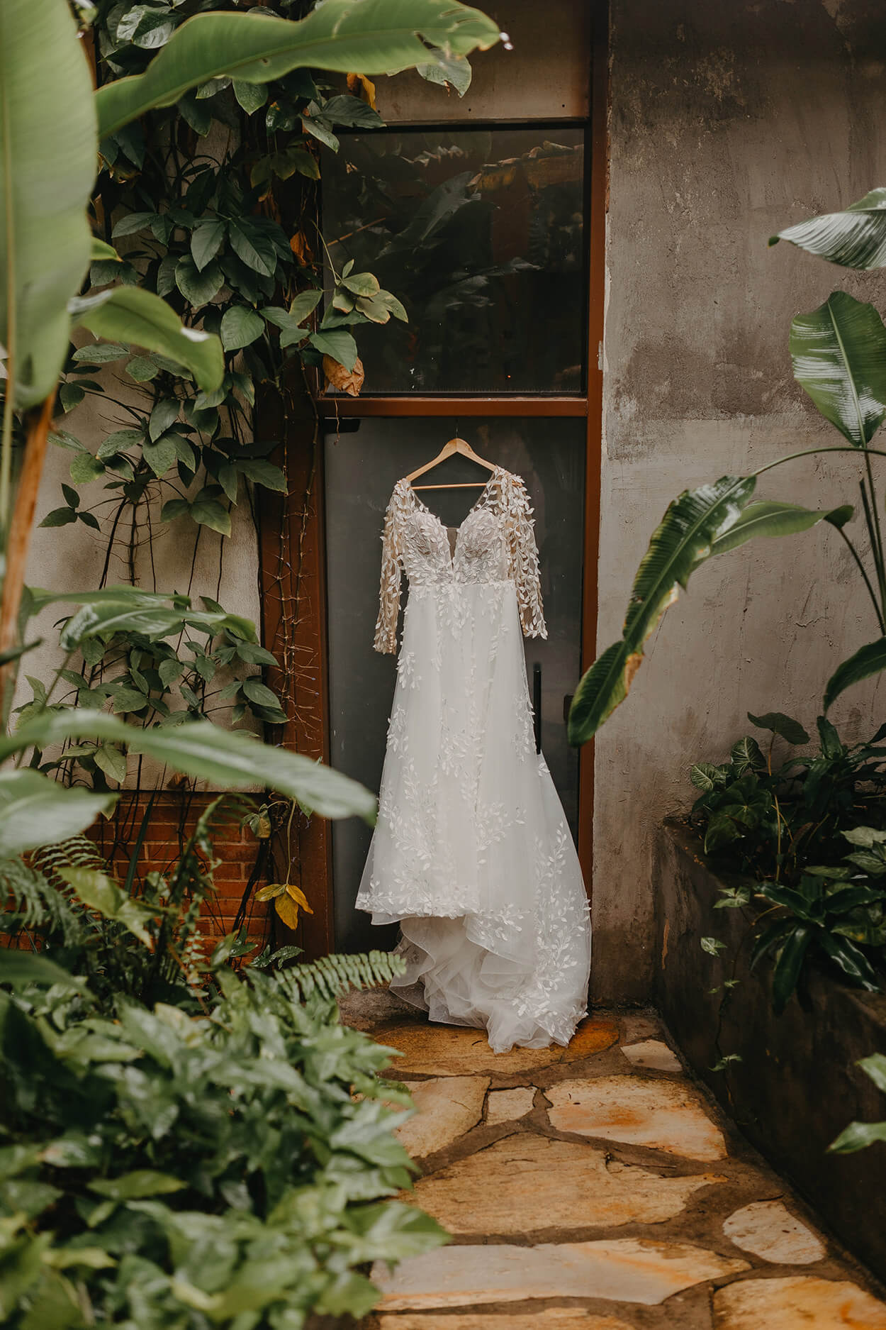 Vestido de noiva com manga longa pendurado no cabide no jardim