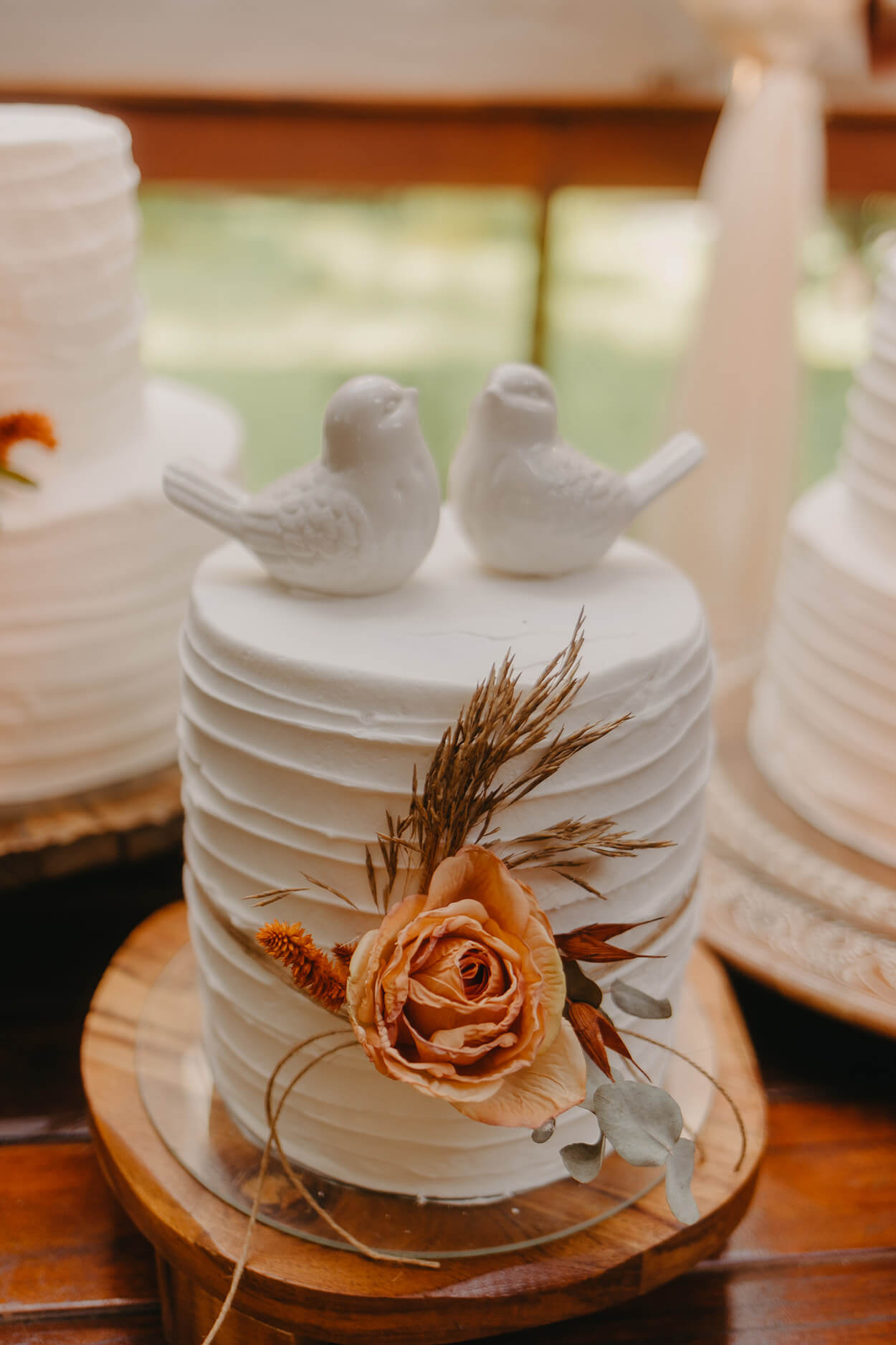 Bolo de casamento branco espatulado com topo de dois passarinhos brancos em porcelana e rosa laranja