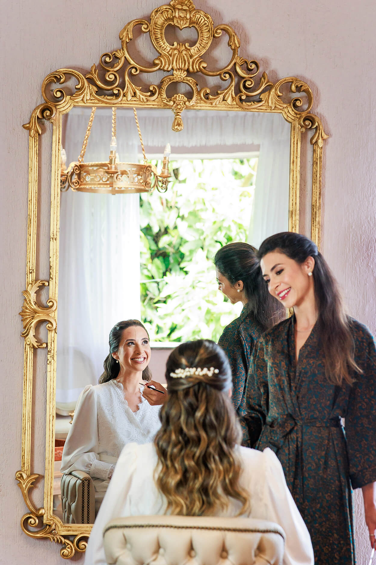 Mulher sendo maquaida em frente a espelho dourado luxuoso
