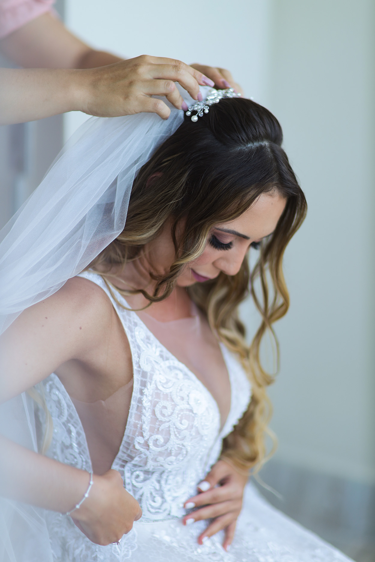 Mulher colocando a grinalda no cabelo da noiva