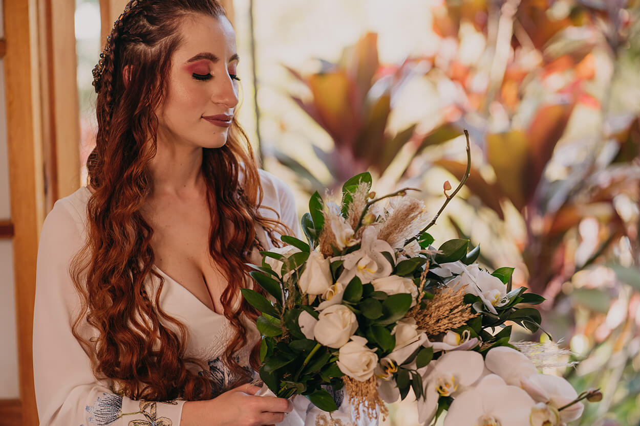 Noiva segurando buquê com rosas brancas