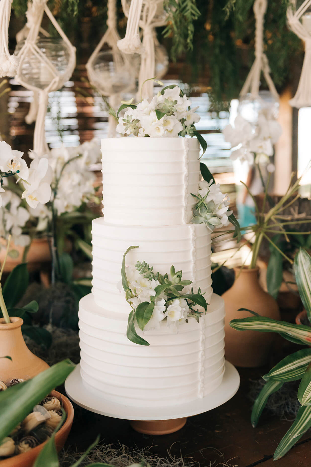 bolo de casamento branco com três andares e flores