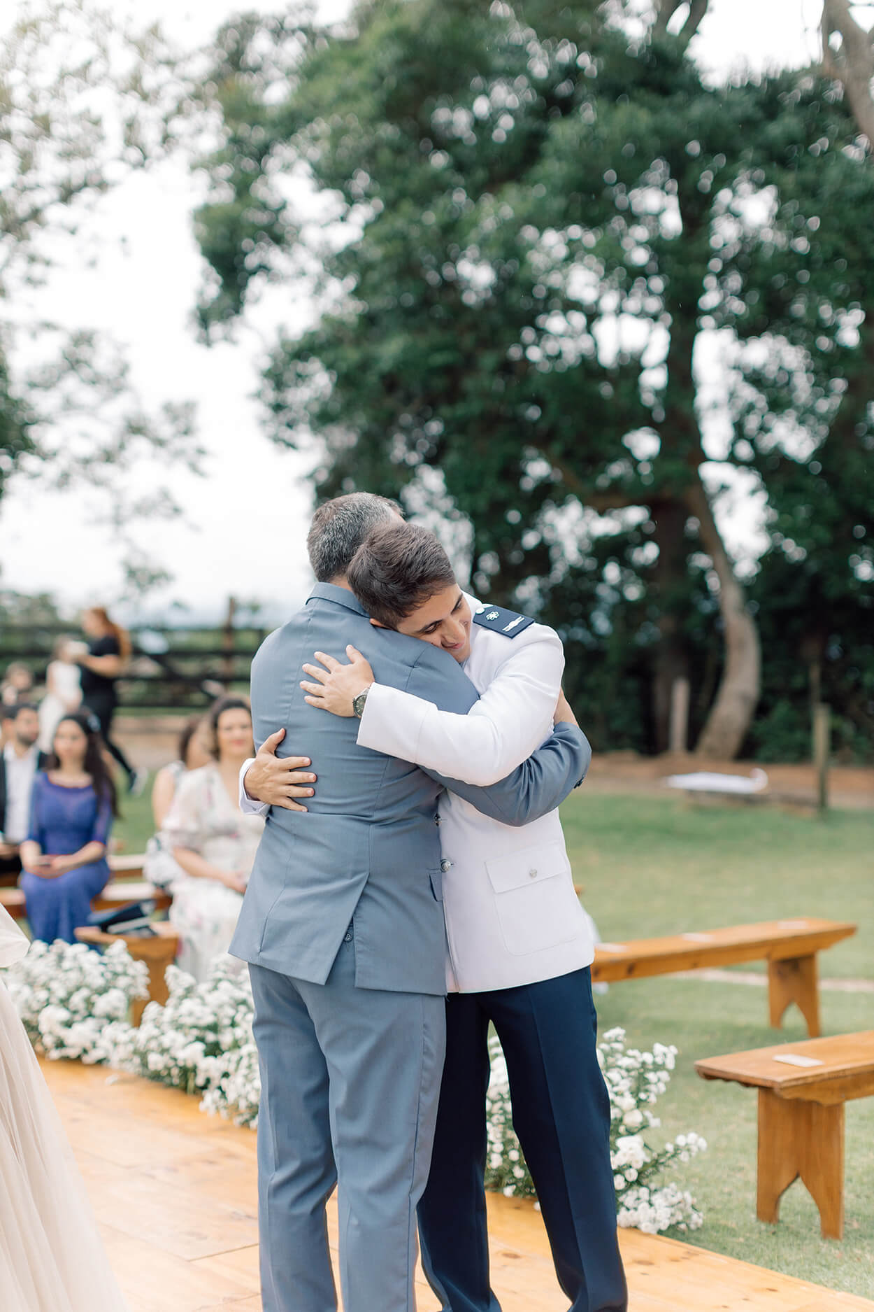 Noivo abraçando seu pai usando terno azul claro