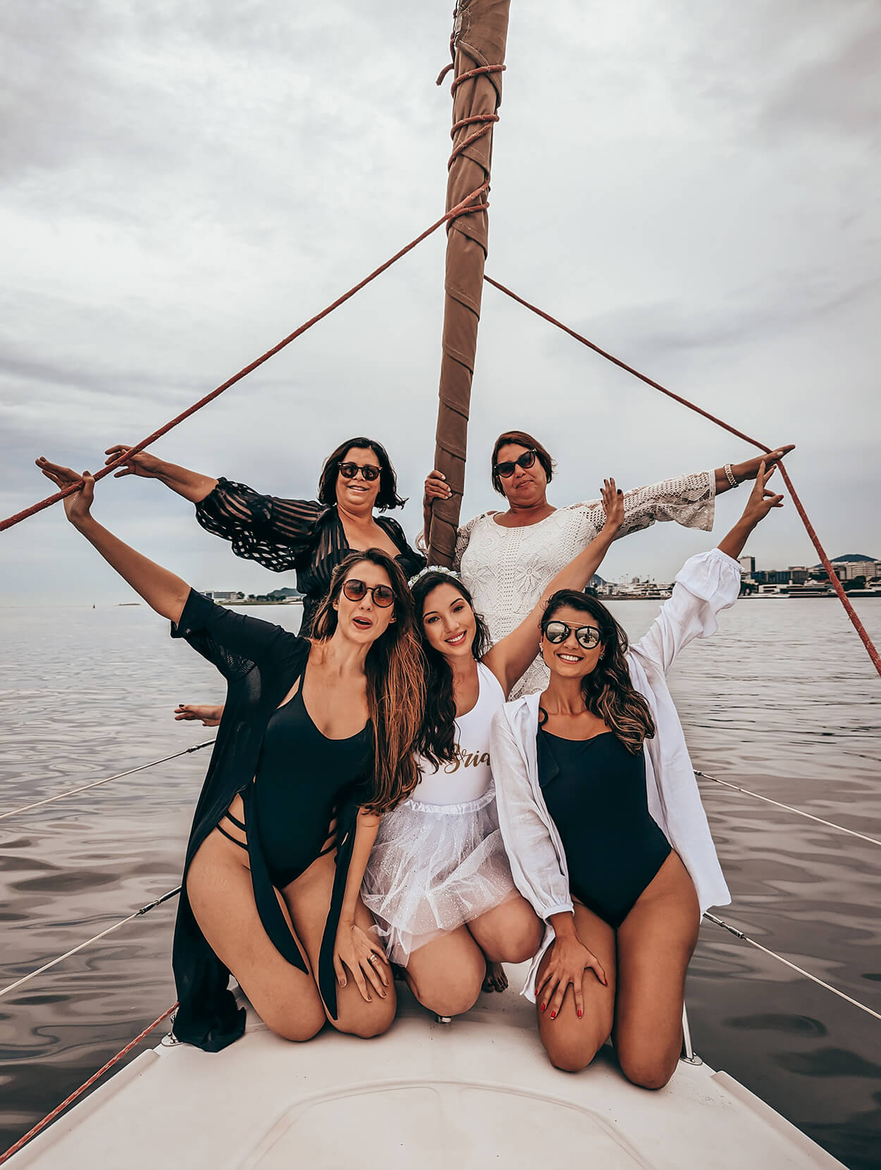 Cinco mulheres posando para foto no veleiro no mar