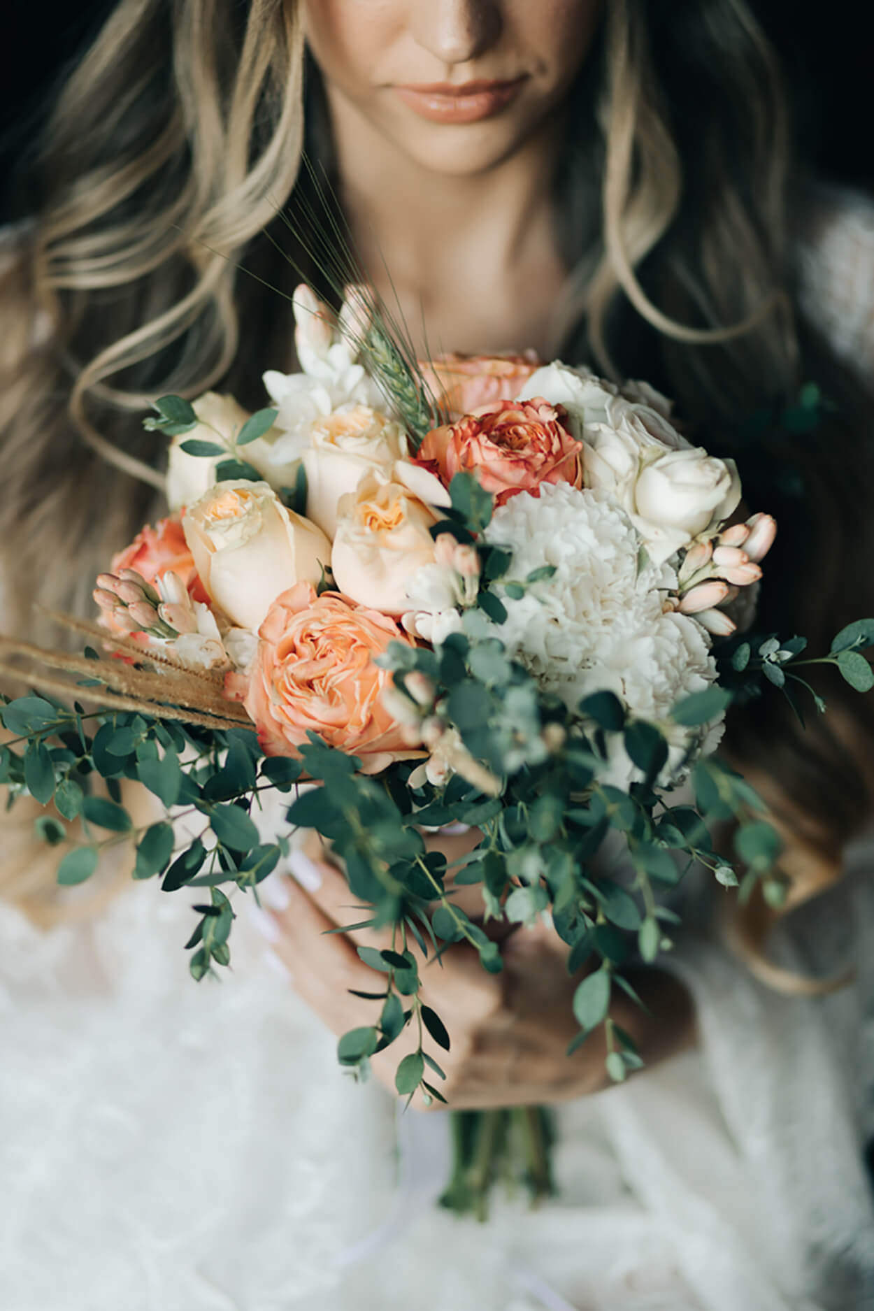 Mulher segurando buquê com rosas laranjas e amarelas e flores brancas