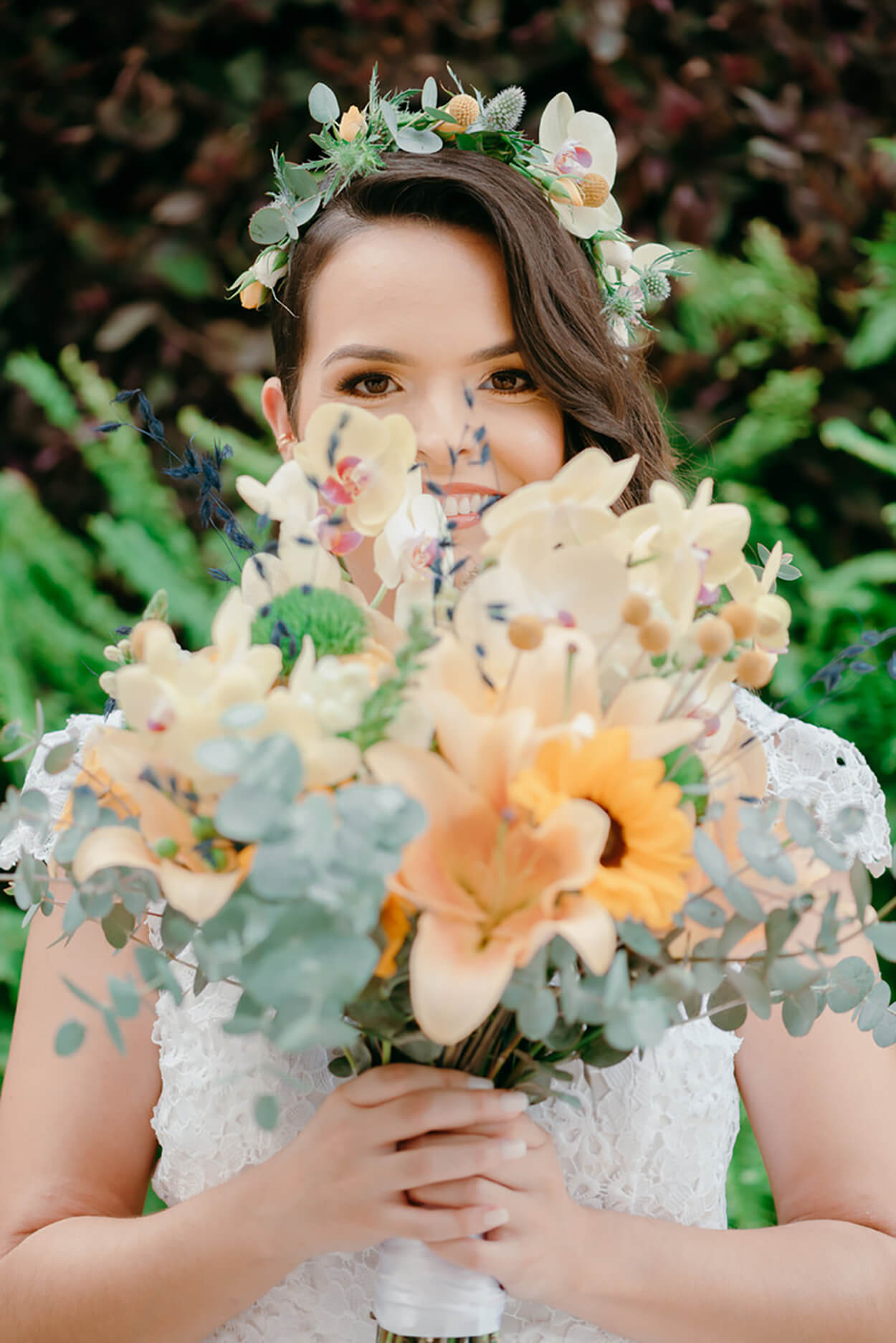 Noiva sorrindo segurando buquê com folhas de eucalipto e girassol