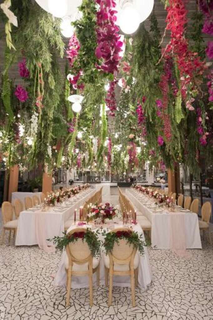 decoração de casamento com mesa comunitária cercadas de flores