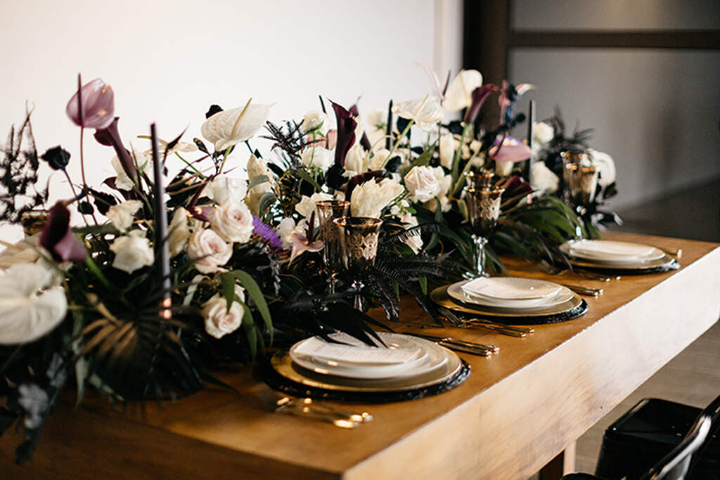 mesa posta com flores brancas ao centro em decoração de casamento