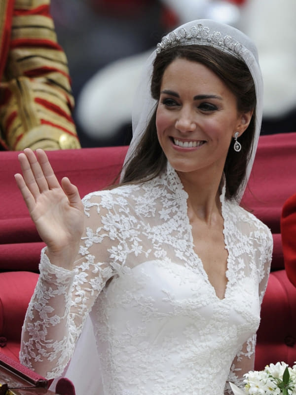 capa post: Britain's Catherine Duchess of Cambridge waves as she travels to Buckingham Palace in the 1902 State Landau along Procession Route after her wedding to Britain's Prince William in Westminster Abbey in London