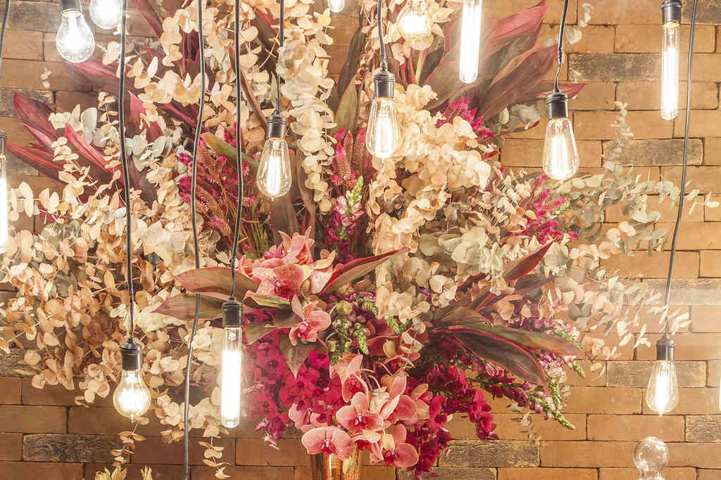 decoração de casamento com lâmpadas suspensas e com flores 