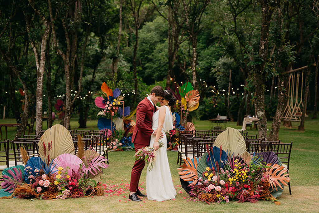 casal se abraçando em uma cerimônia ao ar livre com decoração de casamento colorido 