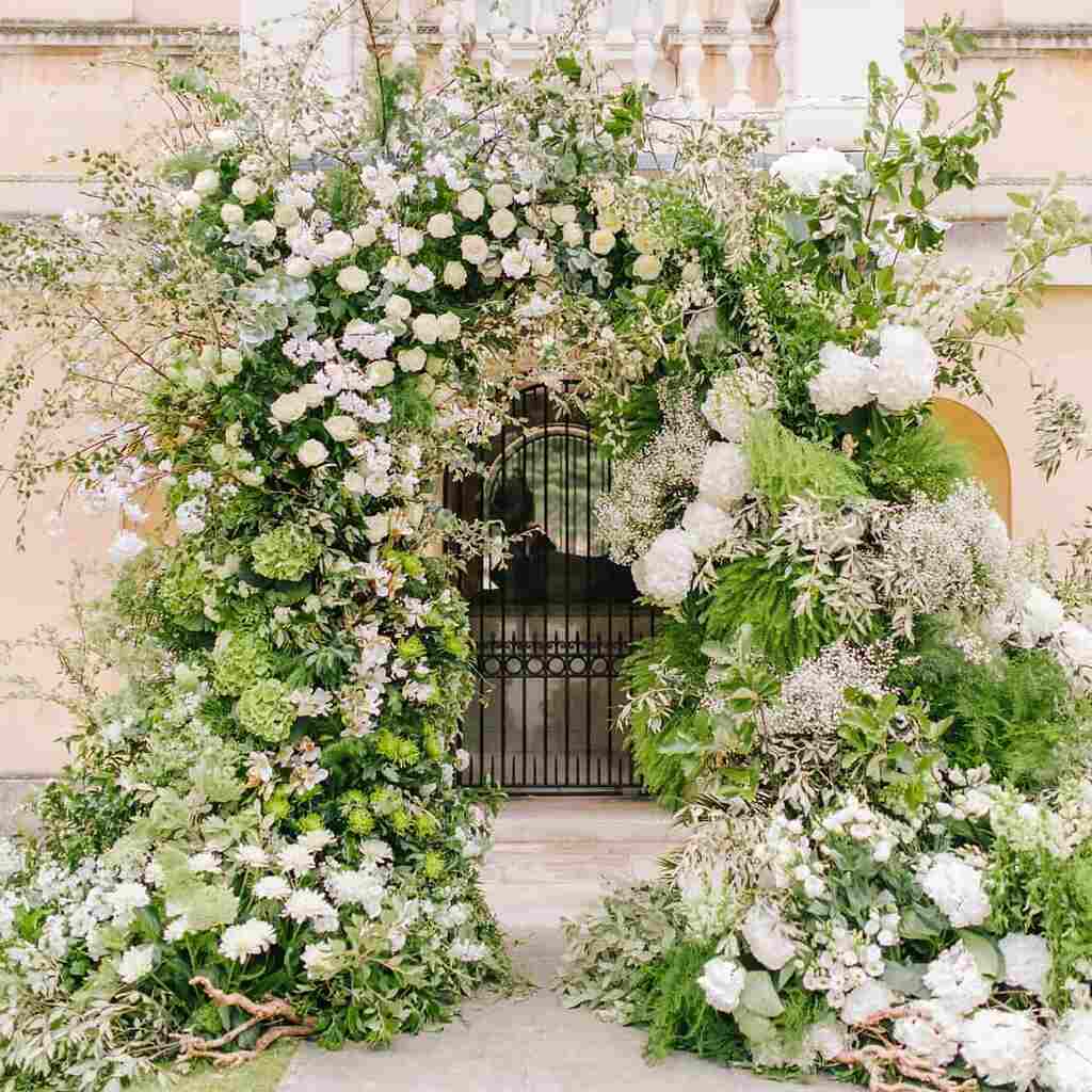 decoração de casamento com arco floral na entrada