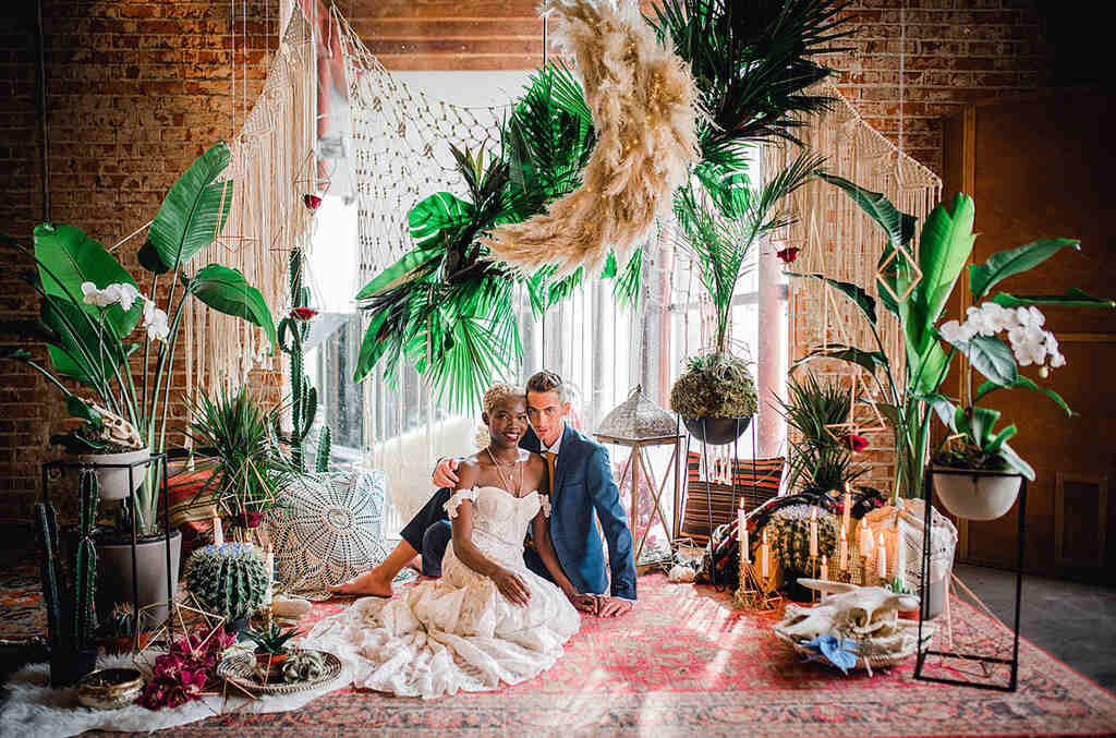 noivos sentados em casamento com decoração de casamento com velas e folha seca e folhas suspensas