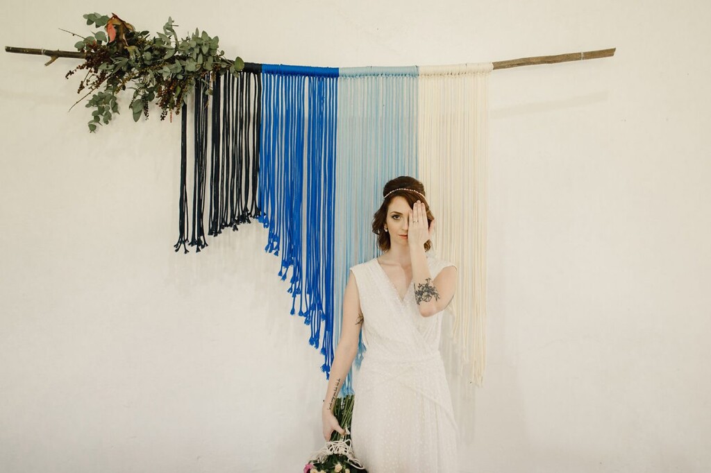 noiva posando para foto com decoração de casamento em macramê coloridos 