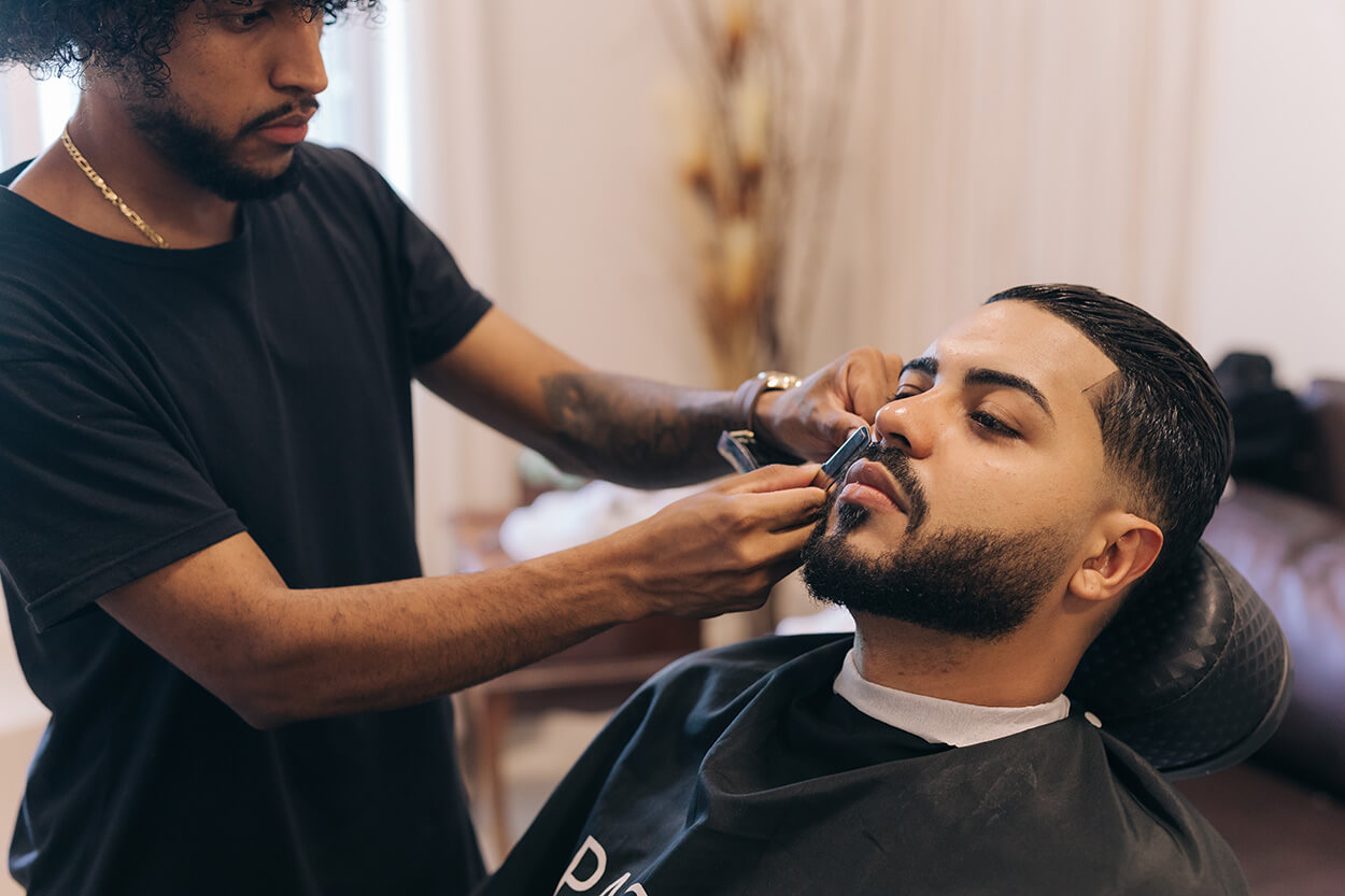Homem fazendo a barba do noivo