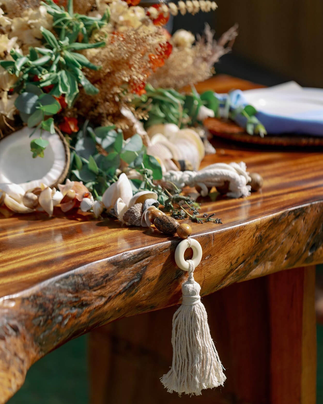Mesa de madeira com folhagens coco e chaveiro em croche