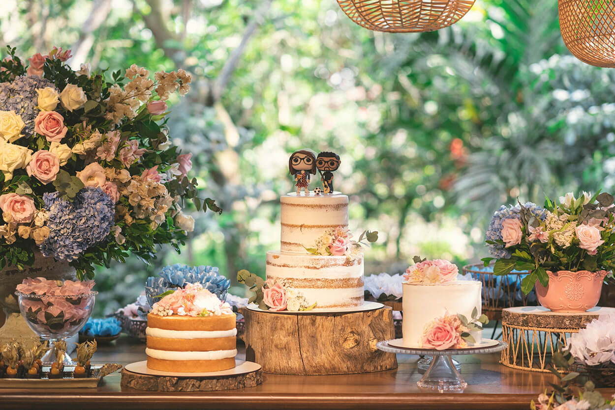 Mesa com três bolos de casamento