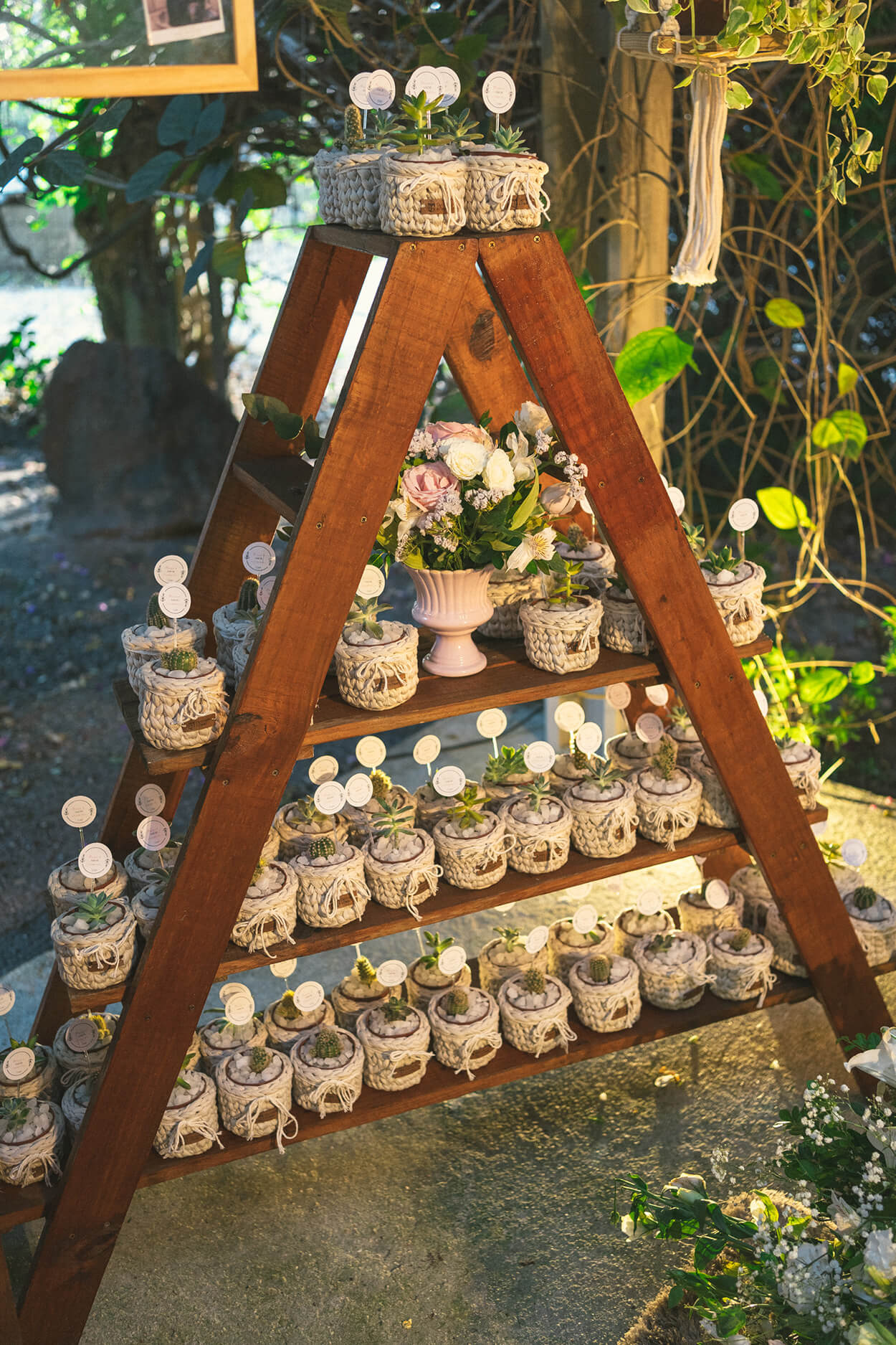 Estante de madeira em formato A com vasinho com flores para lembrancinhas