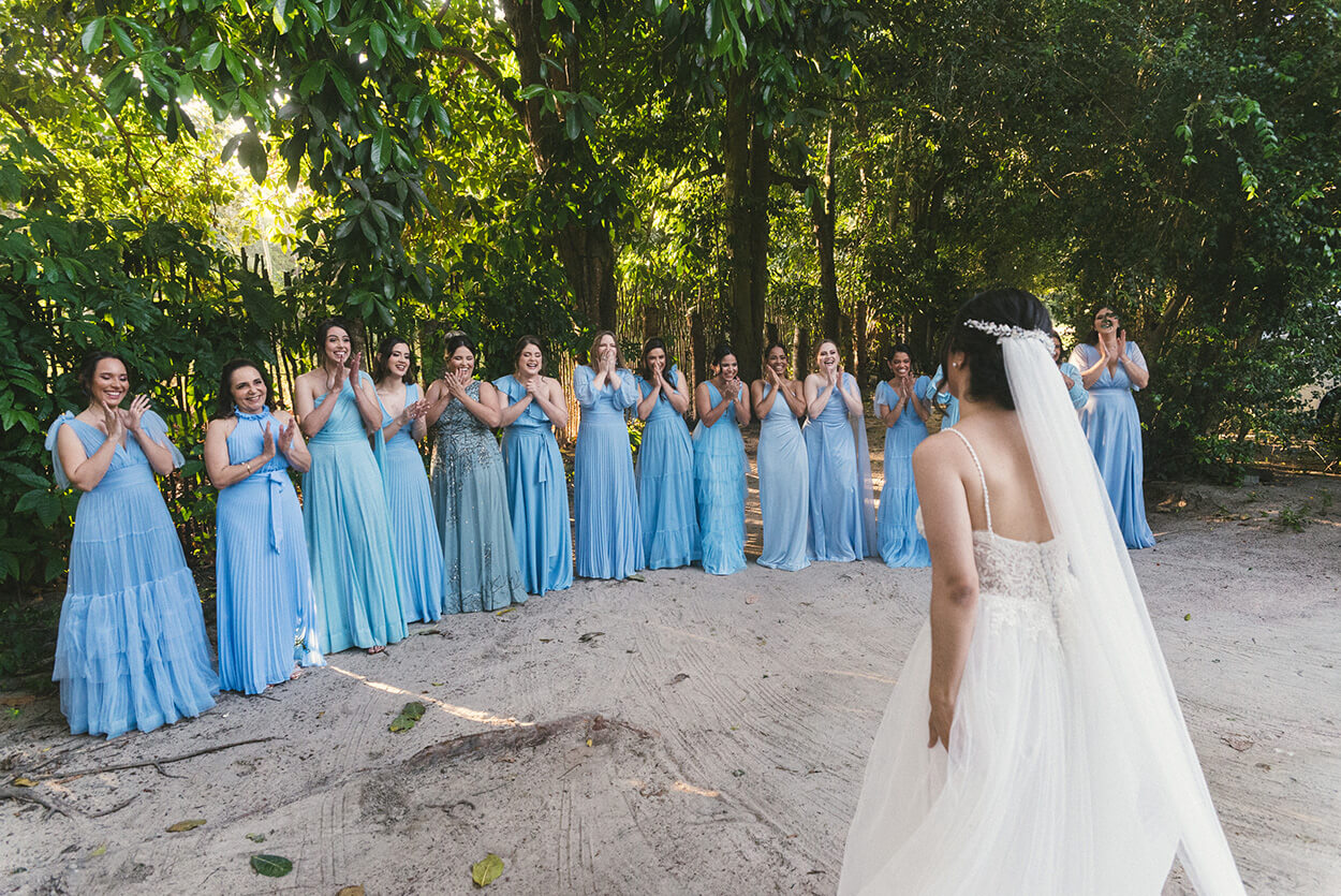 Madrinhas com vestido azul serenity reagindo ao ver a noiva pela primeira vez no jardim