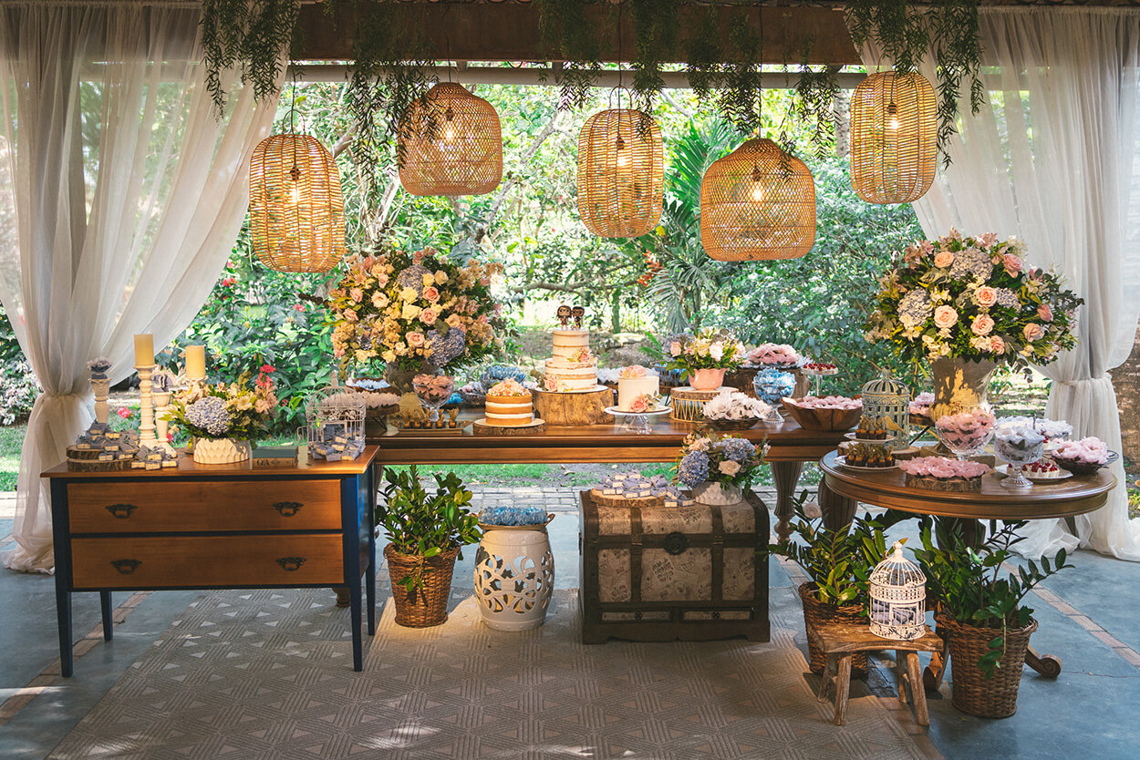 Mesa com bolo de casamento e flores e luminárias