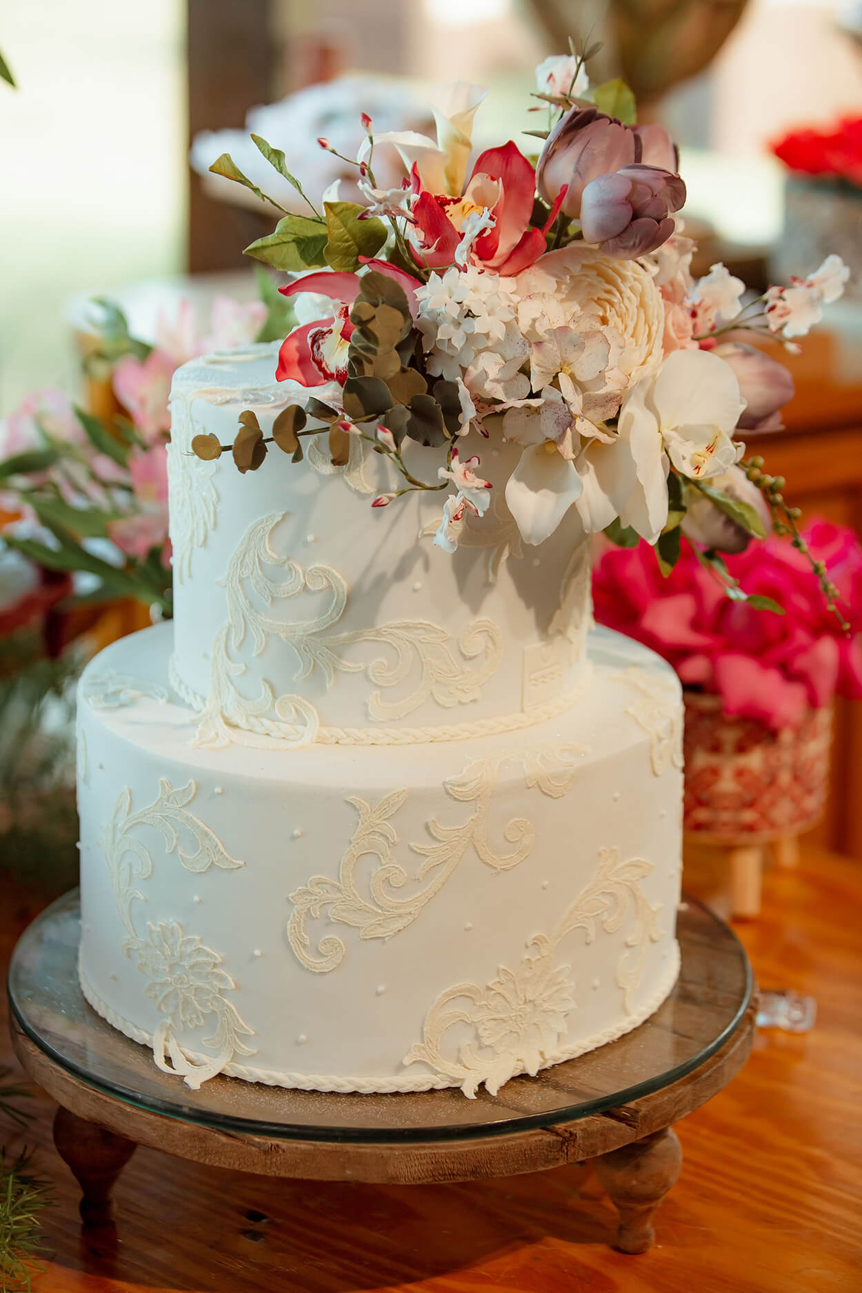 bolo d ecasamenot branco com apliques de bordados e flores no topo