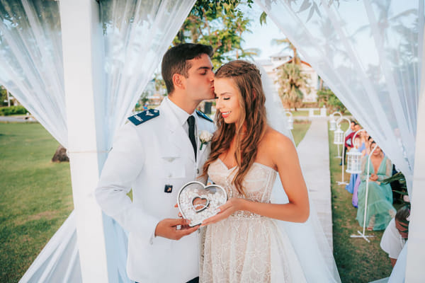 capa post: Noivos segurando o porta alianças