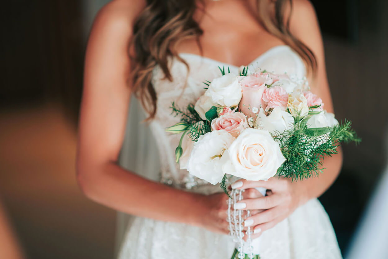 Noiva segurando buquê com rosas brancas e cor de rosa