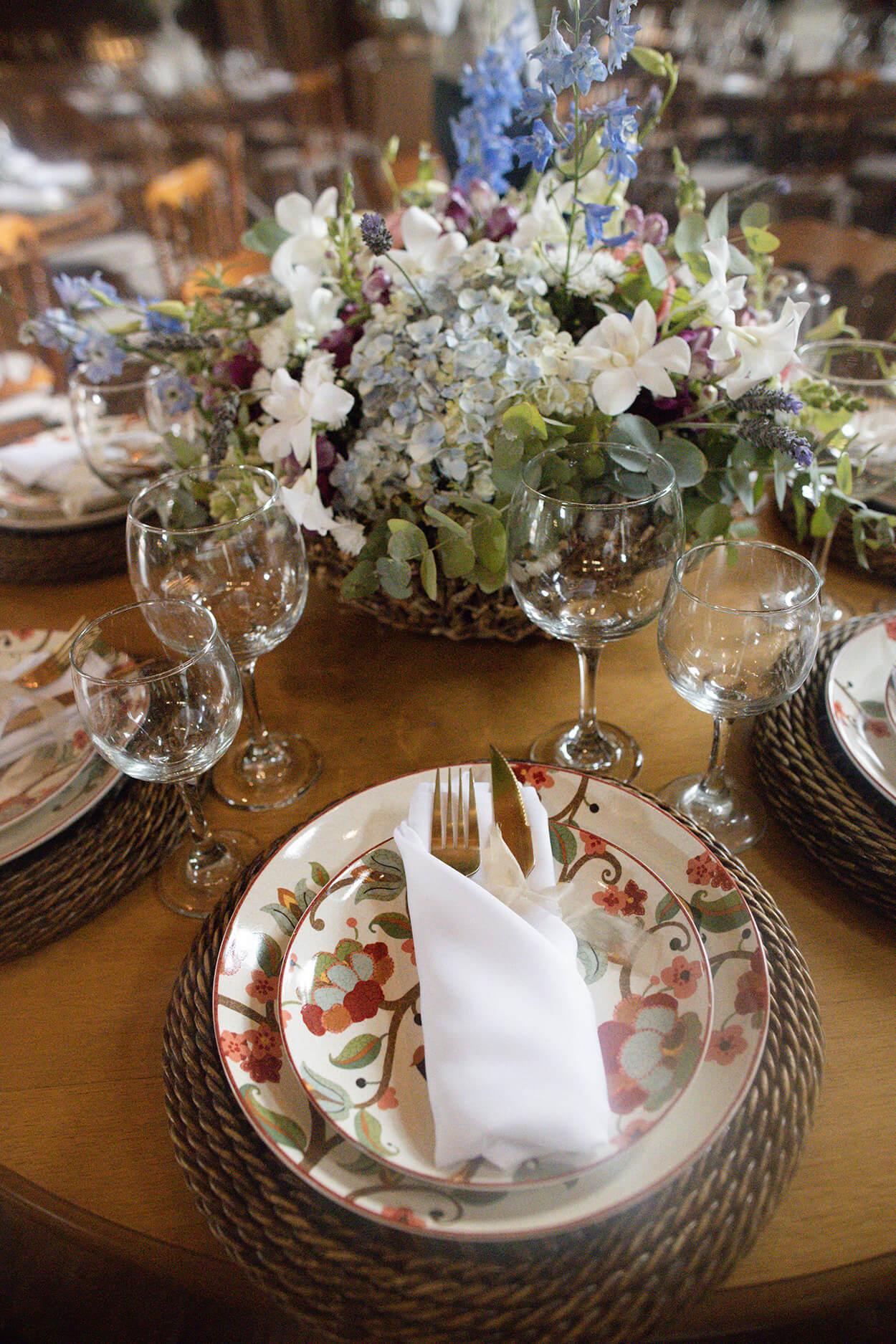 Mesa posta com pratos estampados e centro com flores coloridas